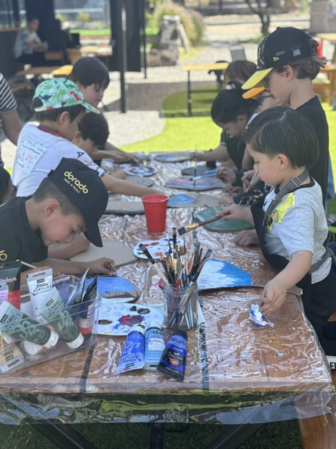 Niños pintando palas en un taller de Dorado Kids